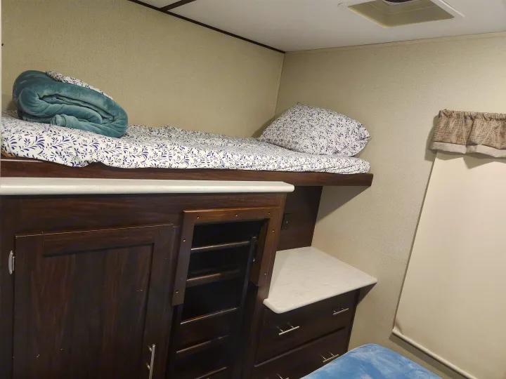 Cozy RV rental sleeping area featuring comfortable bunk beds, built-in storage, and a private window.. Prime Time Lacrosse 2019
