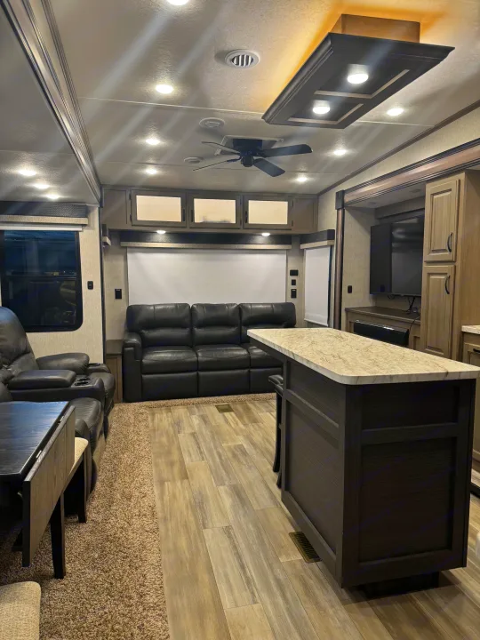 RV rental: Luxurious RV interior featuring a spacious living room with recliners, island kitchen, and entertainment area.. Coachmen Chaparral 2022