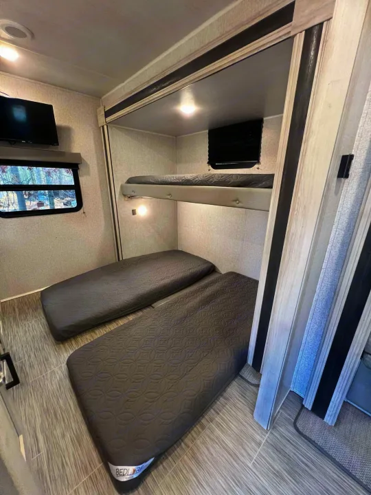 This RV rental's sleeping area features two bunk beds and two floor mattresses, offering ample space for guests.. East to West Silver Lake 2022