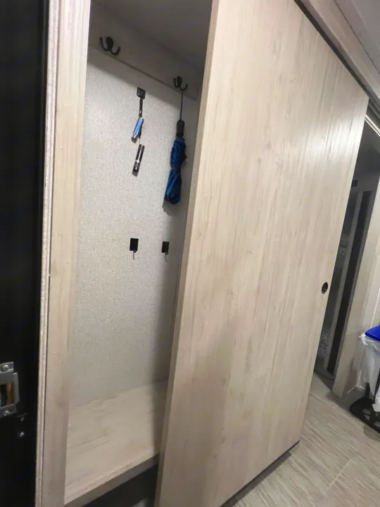 Inside an RV rental: a compact storage area with hooks, a shelf, and a sliding door, keeping travel essentials organized.. East to West Silver Lake 2022