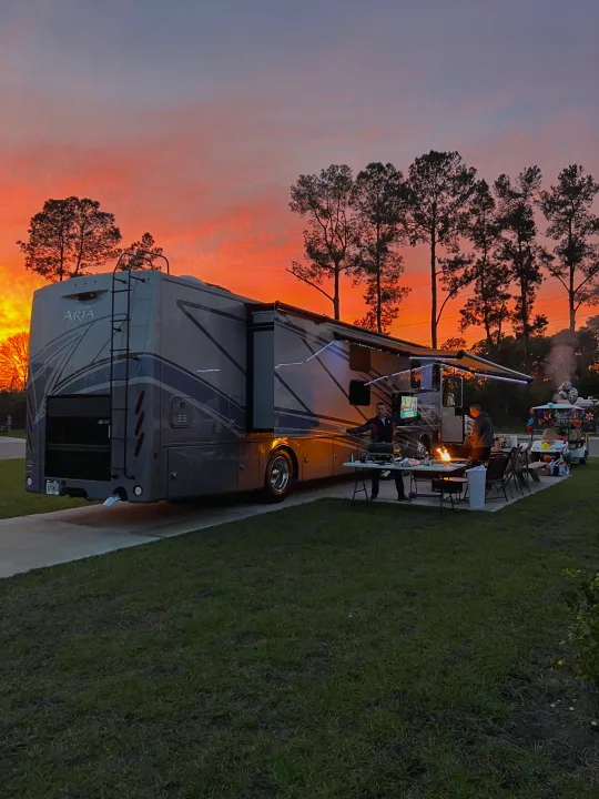 Experience an incredible sunset at your next rv rental campsite, complete with a cozy campfire and outdoor enjoyment.. Thor Aria 2024