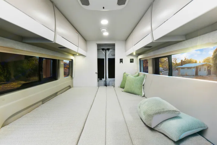 Spacious camper van interior for your next rv rental adventure. Features comfortable bed/seating and overhead storage.. Entegra Coach Ethos 2024