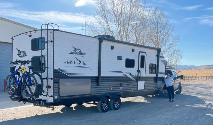 An RV rental, a Jay Flight travel trailer, equipped with bikes, sits parked as a person poses for a trip.. Jayco Jay Flight 2024