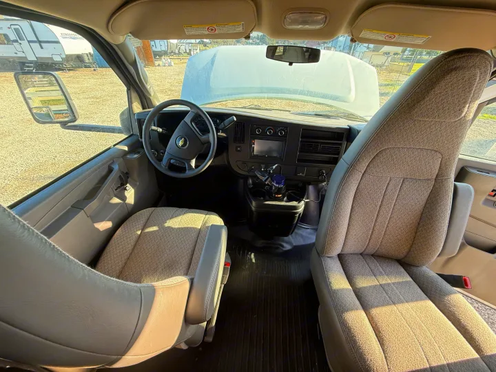 RV rental cockpit view, showing the steering wheel, dashboard, and front seats with the hood open outside.. 1HAGGUC78MN008793 Cross Trail 2022