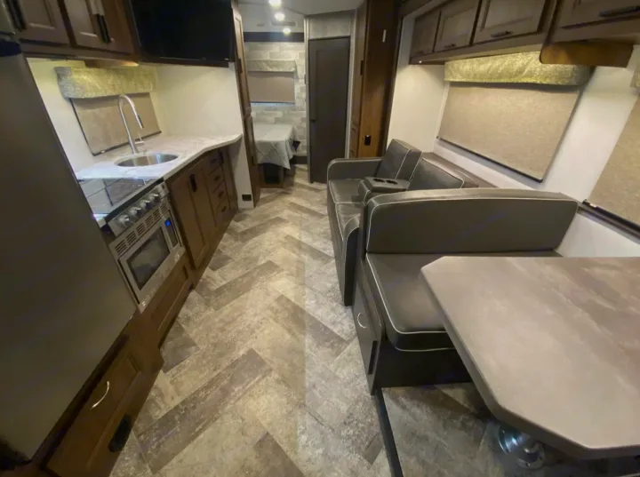 Spacious RV rental interior: modern kitchen, comfortable dinette seating, and stylish herringbone flooring.. Forest River Forester 2020