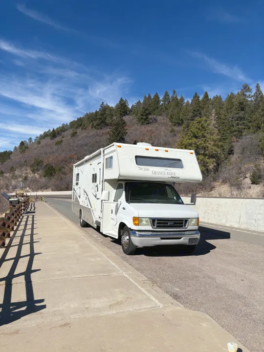 White Jayco RV rental parked on a scenic mountain bridge, ready for your road trip adventure.. Jayco Granite Ridge 2003