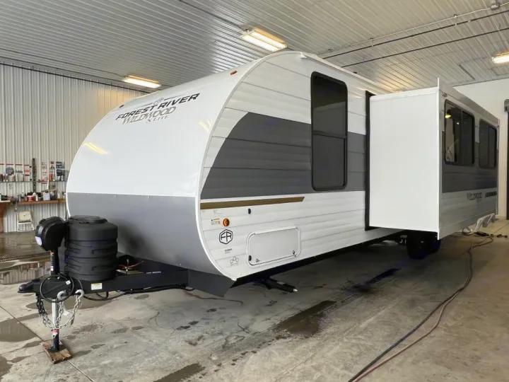 A modern, two-tone RV travel trailer, featuring a slide-out, perfect for your next RV rental adventure. Indoors.. Forest River Wildwood X-Lite 2025
