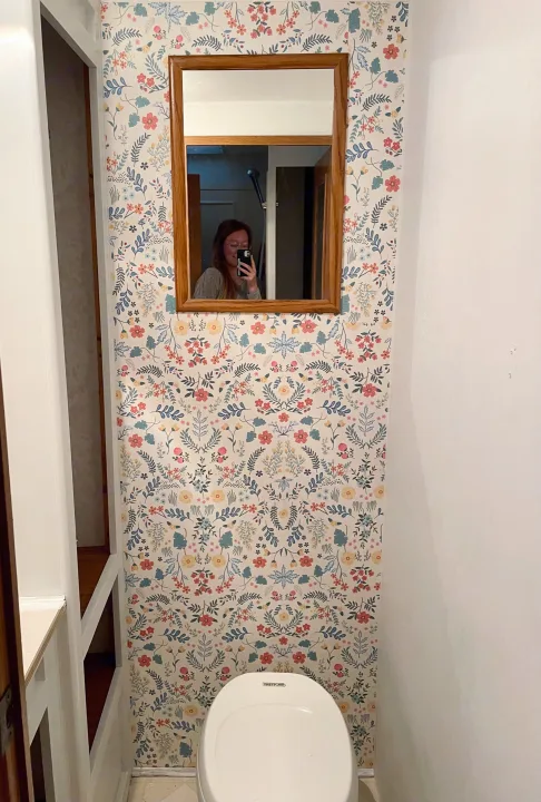 RV rental interior: A compact bathroom featuring vibrant floral wallpaper, a white toilet, and a mirror reflection.. Jayco Eagle 1998