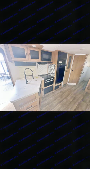 Modern RV rental kitchen featuring light wood cabinets, black appliances, a sink, and stylish backsplash.. Forest River Cherokee Alpha Wolf 2023