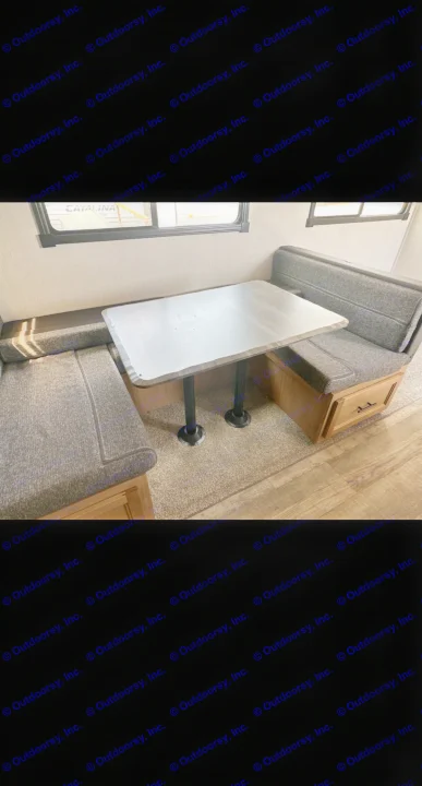 Cozy RV rental dinette featuring dark upholstered benches, a sturdy table, and ample storage, perfect for your camper.. Forest River Cherokee Alpha Wolf 2023
