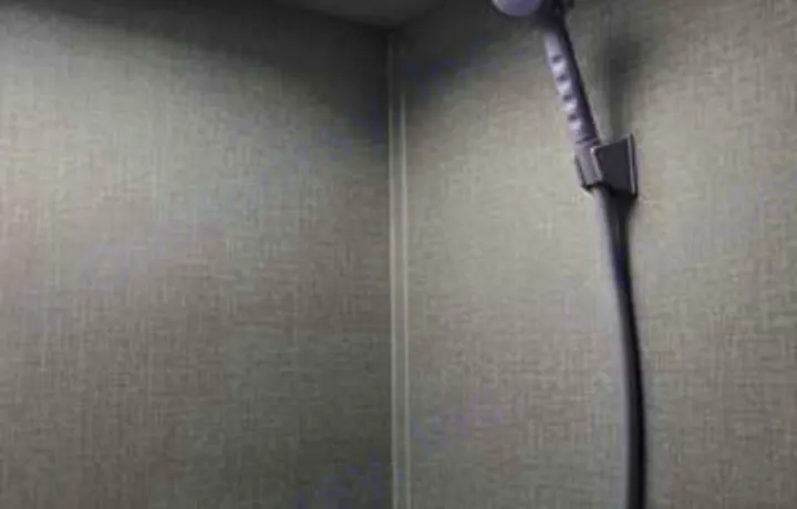 RV rental travel comfort: Interior view of a compact shower with handheld showerhead.. Coachmen Clipper 2022