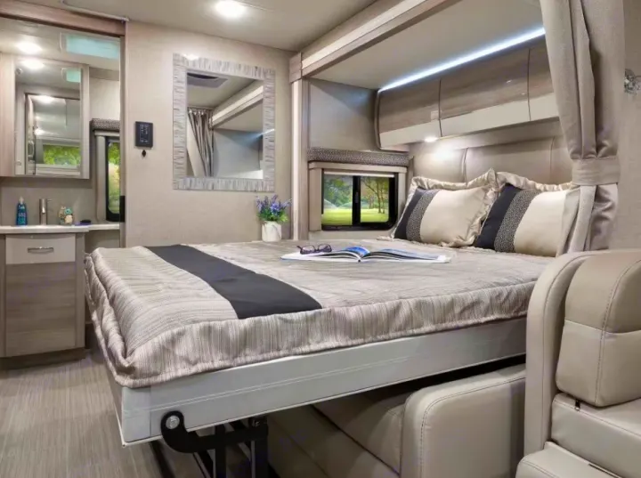 Modern RV interior with a space-saving murphy bed, sofa, and vanity. Perfect for your rv rental.. Thor Delano 2021