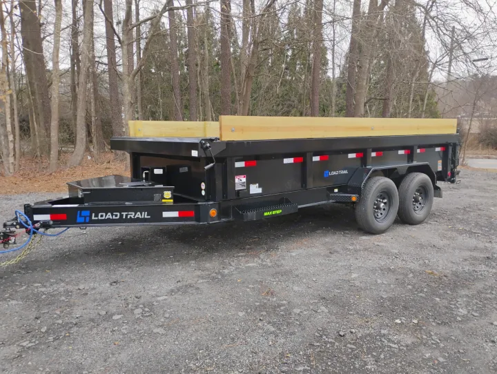 Black Load Trail dump trailer with wooden sides on gravel. Perfect for heavy-duty projects. Explore utility trailer rental options, alongside RV rental.. Load Trail Dump Trailer 2025