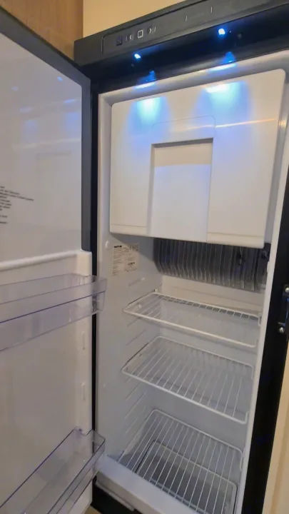 Clean, empty RV rental refrigerator interior, ready for your trip. Features bright LED lights and wire shelves.. Ford Transit Rimor Evo Sound 7 2022