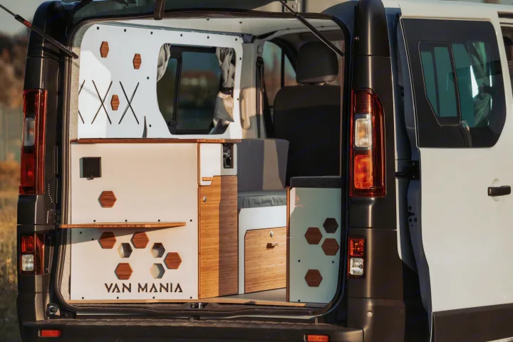 Customized camper van interior, showcasing smart storage, wooden accents, and seating, ready for your next rv rental adventure.. Renault Trafic 2025