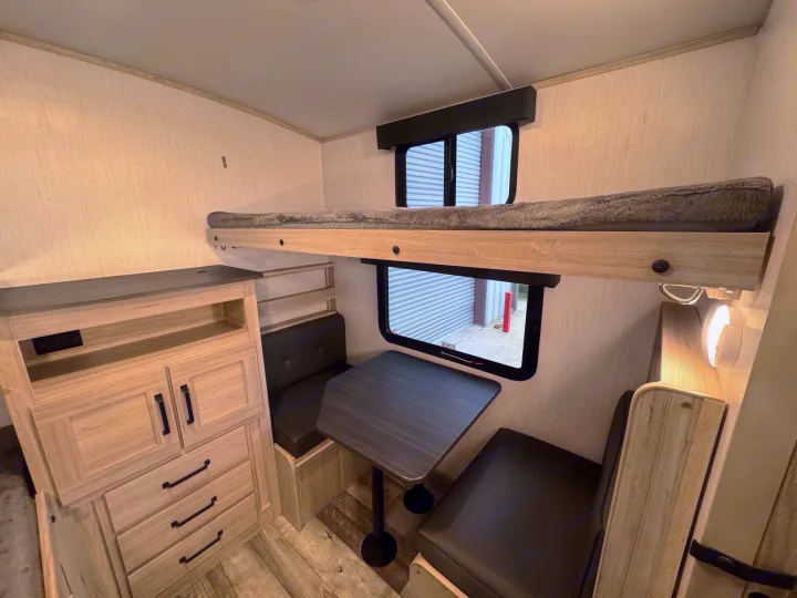 Spacious RV rental bunkhouse interior featuring a comfortable bunk bed, dinette, and ample storage for your next adventure.. Heartland Sundance 2023