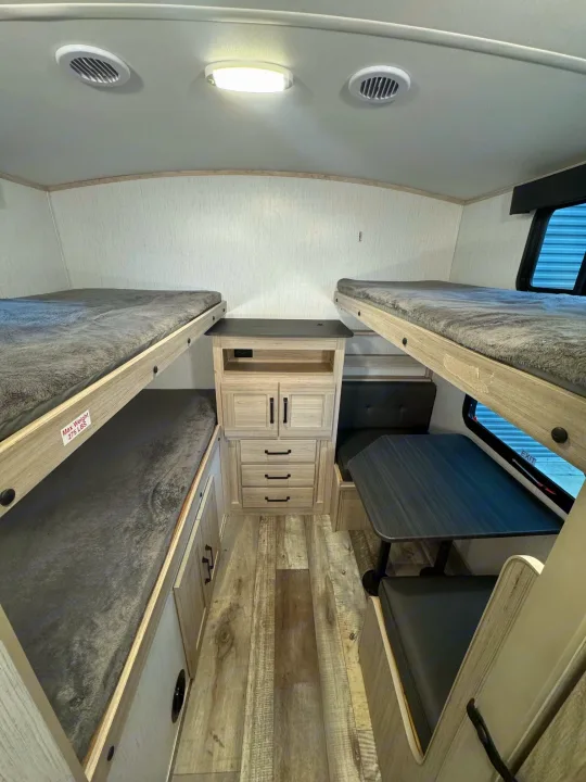 This RV rental features a well-equipped bunkhouse with cozy beds, a dinette, and built-in storage.. Heartland Sundance 2023