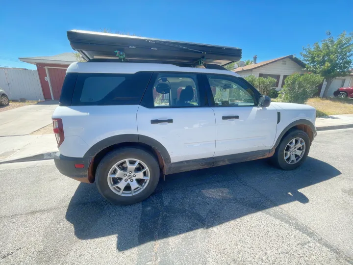This white Ford Bronco Sport with a rooftop tent, a versatile RV rental option for camping and overlanding adventures.. Ford Bronco sport 2022