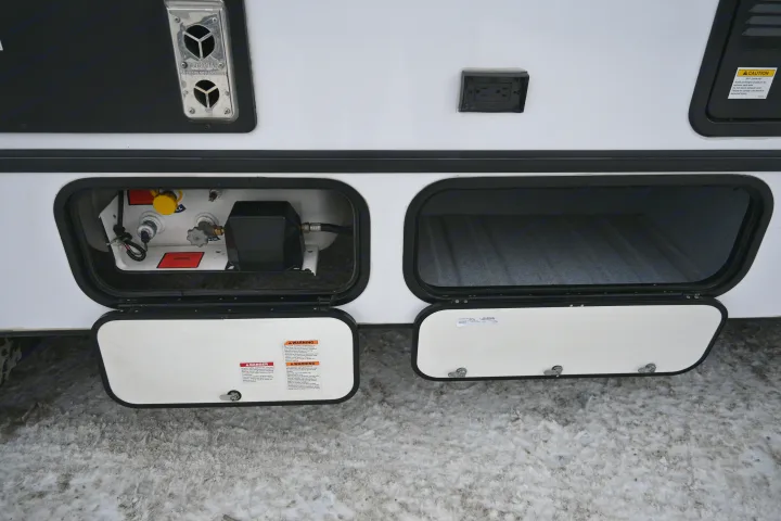 RV rental side with open propane hookup and storage compartments. Visible vents & outdoor power outlet for full utility access.. Forest River Sunseeker - LE Series M-2850S 2024