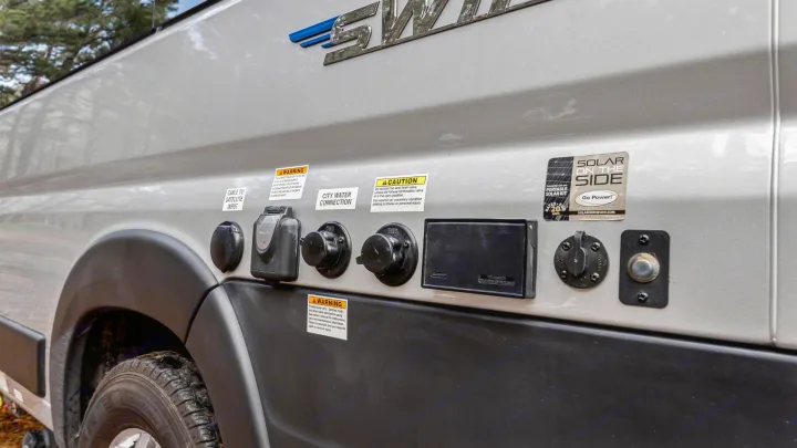 This RV rental shows detailed external utility hookups for electrical, water, cable/satellite, and solar power connections.. Jayco Swift 2022