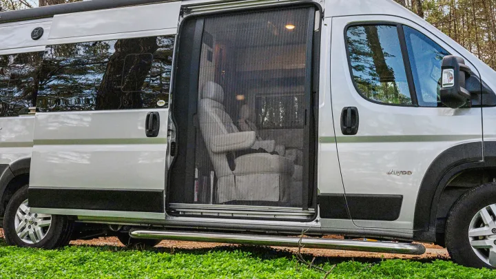 Silver Jayco RV rental with open side door and mesh screen, revealing interior swivel chairs. Ready for your next adventure.. Jayco Swift 2022