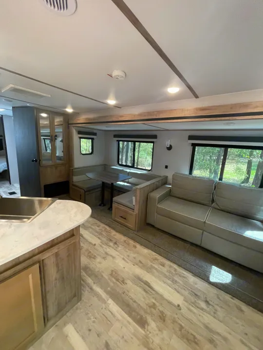Spacious RV rental interior with a modern kitchen, dinette, and sofa, offering comfortable travel living space.. Gulf Stream Innsbruck 2023