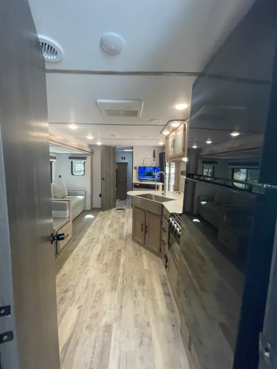Spacious, modern RV rental interior with a fully equipped kitchen, comfortable living area, and light wood flooring, perfect for your next adventure.. Gulf Stream Innsbruck 2023