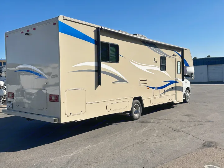 This Class C RV rental, featuring blue and white accents, is ready for adventure on a sunny day.. Winnebago Minnie Winnie 2015