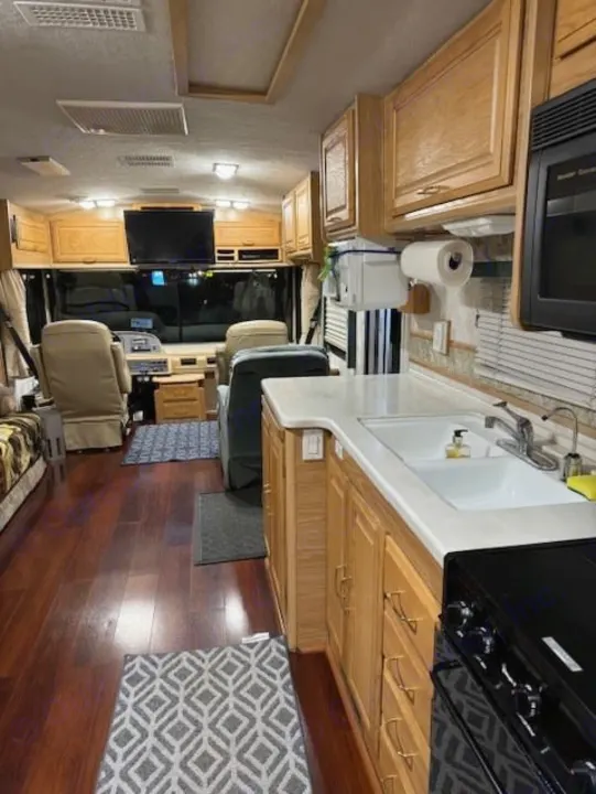 Spacious RV rental interior with full kitchen, hardwood floors, and comfortable living area.. Fleetwood 39/MH 2000