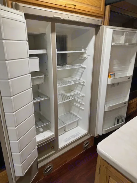 Spacious, clean double-door RV rental refrigerator, with shelves & bins, ready for your travel essentials.. Fleetwood 39/MH 2000