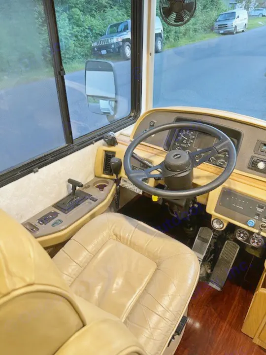 Explore this rv rental's spacious cockpit: comfy driver's seat, controls, and a clear road view.. Fleetwood 39/MH 2000