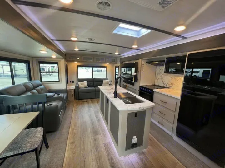 Step inside this modern RV rental's spacious interior, featuring a full kitchen, living area, and dining space.. Forest River Salem Hemisphere 2024