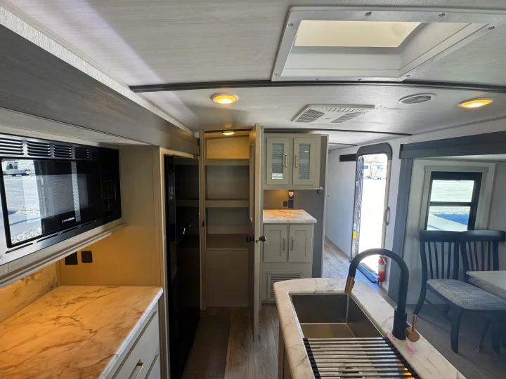 Experience comfort in this RV rental! Modern kitchen features marble-look counters, sink, microwave, and fridge, plus ample pantry space.. Forest River Salem Hemisphere 2024
