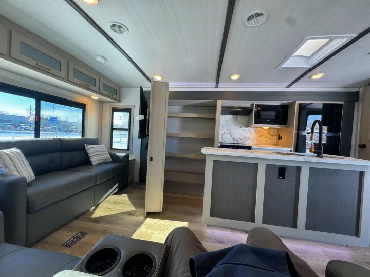 Explore this modern RV rental: a bright interior featuring a comfortable sofa, full kitchen, and cozy amenities for travel.. Forest River Salem Hemisphere 2024