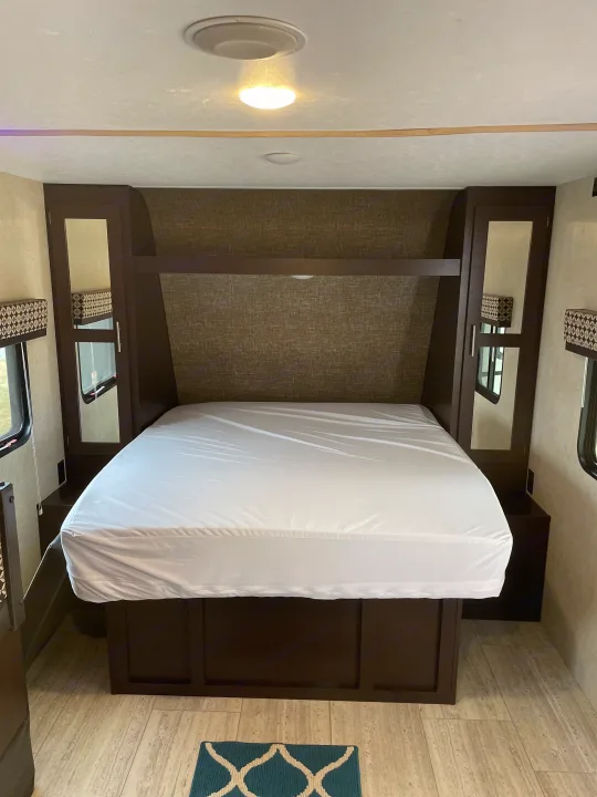 This RV rental offers a comfortable bedroom with a queen bed, mirrored closets, and wood-look flooring. Ready for travel!. Sportsmen Sportsmen Trailer 2017