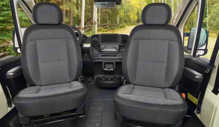RV rental interior: Front cabin shows two grey fabric seats, a modern dashboard, and a beautiful forest road view.. Winnebago Solis NPF 2025