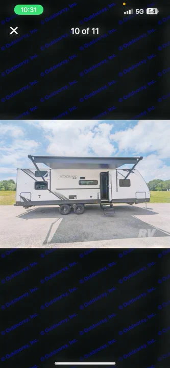 A modern white Kodiak travel trailer, ready for your next rv rental. Parked on asphalt with awnings extended.. Dutchmen Kodiak SE 2024