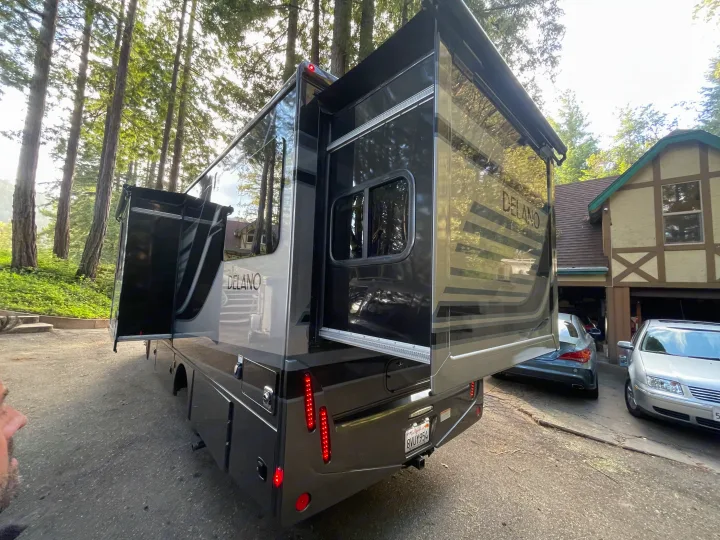 Spacious RV rental, a Delano motorhome, with slide-outs extended in a scenic wooded area, ready for adventure.. Thor Delano Sprinter 2020