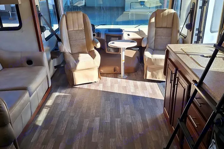 Inside an RV rental: a spacious interior featuring comfortable seating, a kitchen, and front driving area with a small table.. FR3 FR3 Motorhome 2018