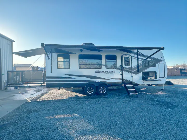 This Momentum G-Class travel trailer, a toy hauler with an awning and outdoor kitchen, is ready for your next RV rental adventure.. Grand Design Momentum 2022