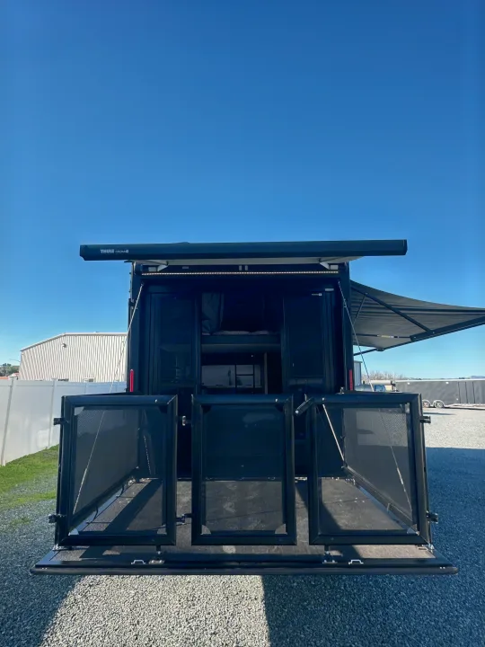 This black RV rental, with its extended rear ramp patio & dual awnings, offers spacious outdoor living under a clear sky.. Grand Design Momentum 2022