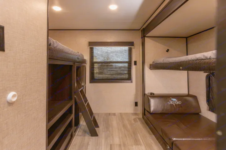 RV rental bunkhouse featuring two bunk beds, a ladder, window with blinds, and a Jayco sofa-bed.. Jayco Jayflight 32BHDS.G 2022