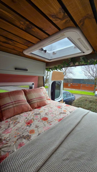 Experience cozy RV rental living! This campervan features a warm wooden ceiling, bright skylight, and comfy floral bed.. Citroen Relay L3H2