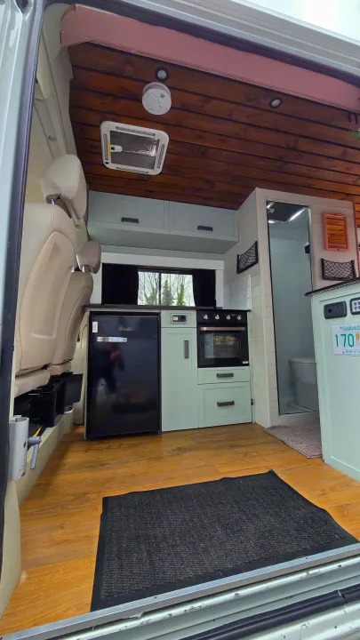 This RV rental shows a modern, cozy camper van interior with a full kitchen, bathroom, and wooden ceiling.. Citroen Relay L3H2