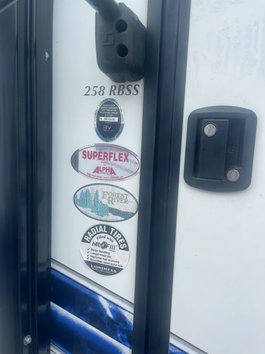 Side of a Forest River 258 RBSS RV/travel trailer, showing Superflex roofing, NitroFill tires, and compliance details, great for rv rental.. Palomino Solaire Ultra Lite 2020