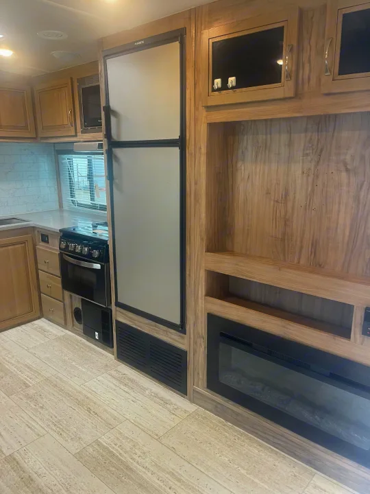 RV rental: Bright kitchen with appliances, Dometic fridge, and a cozy entertainment area with fireplace. Modern interior.. Palomino Solaire Ultra Lite 2020