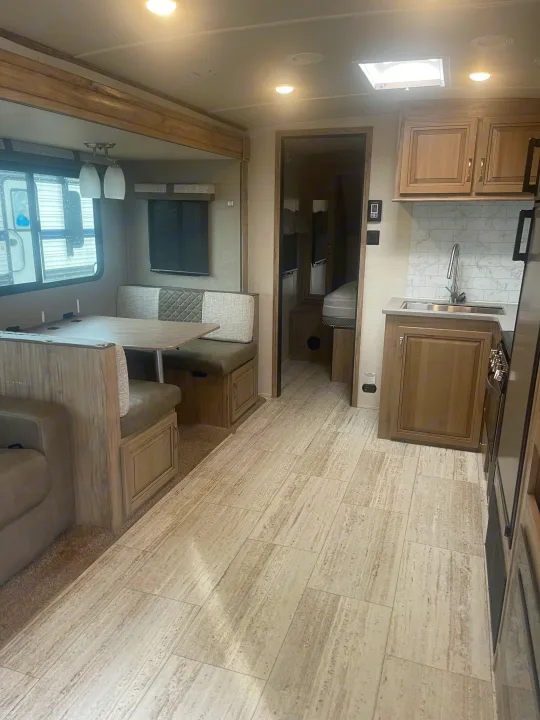 Spacious RV rental interior, showcasing a bright dinette, kitchen area, and a glimpse of the bedroom. Modern and clean design.. Palomino Solaire Ultra Lite 2020