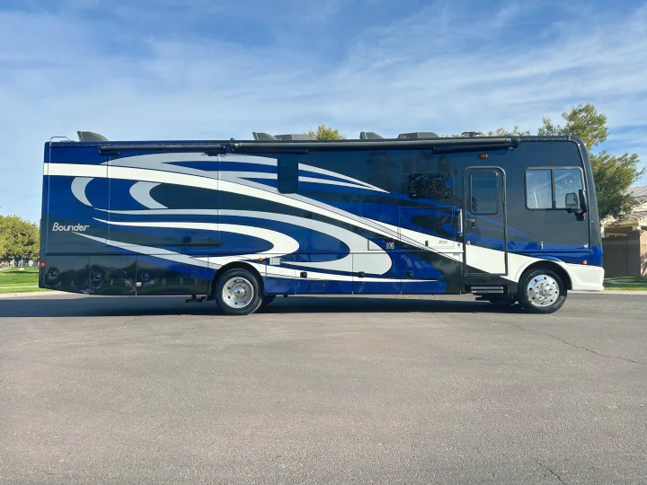 This striking blue and white Bounder motorhome is a perfect RV rental, parked on asphalt and ready for adventure.. Fleetwood Bounder 2018