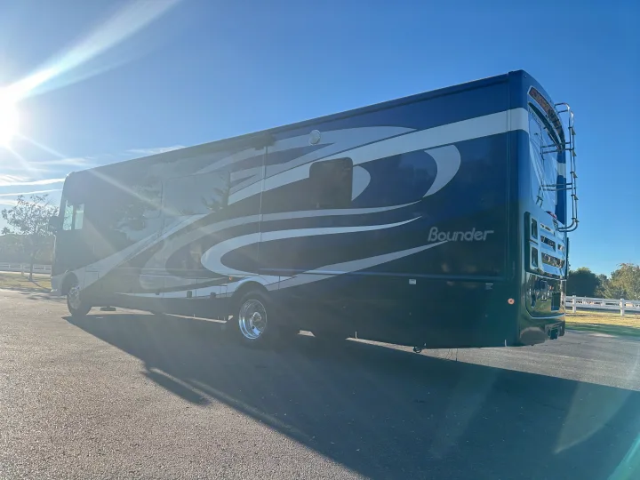 Stunning blue and gray Fleetwood Bounder RV rental parked on asphalt, glowing in the bright sun.. Fleetwood Bounder 2018