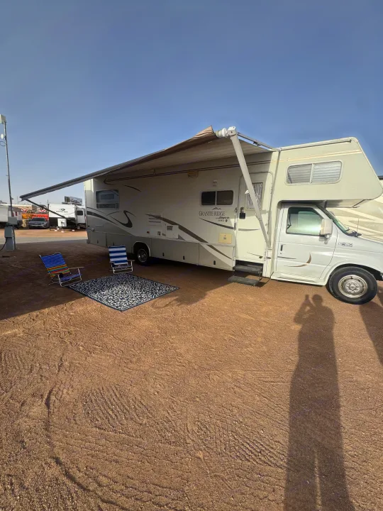 Enjoying a sunny day at the RV site. This spacious rv rental has an extended awning, chairs, and rug for comfort.. Jayco Granite Ridge 2003